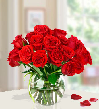 15 Red Roses with fillers in a glass vase. Surprise the Lady