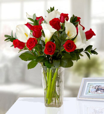 12 Red Rose and 6 White Calla Lilies with fillers in a glass vase. Classicaly